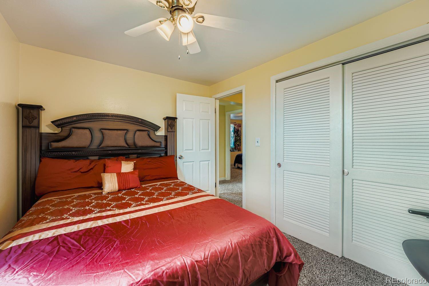 361 East Thomas Avenue Byers, CO 80103 - Photo 18 of 28 a bedroom with a bed and a chandelier