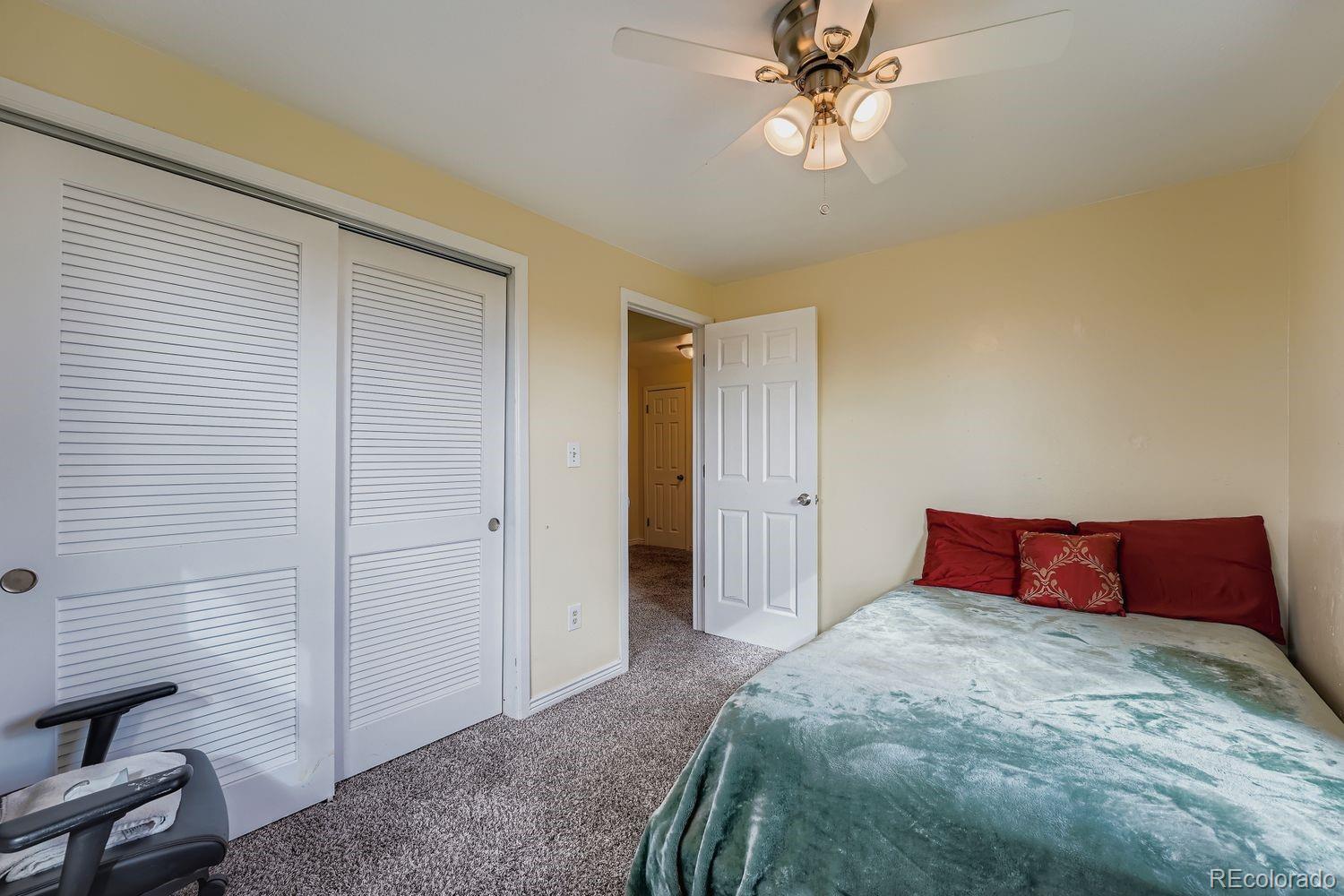 361 East Thomas Avenue Byers, CO 80103 - Photo 20 of 28 a bedroom with a bed and a chandelier
