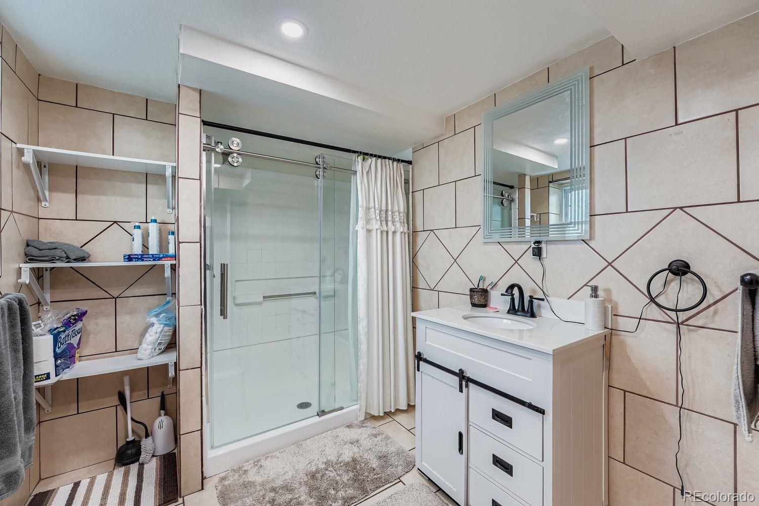361 East Thomas Avenue Byers, CO 80103 - Photo 23 of 28 a bathroom with a sink vanity and a shower