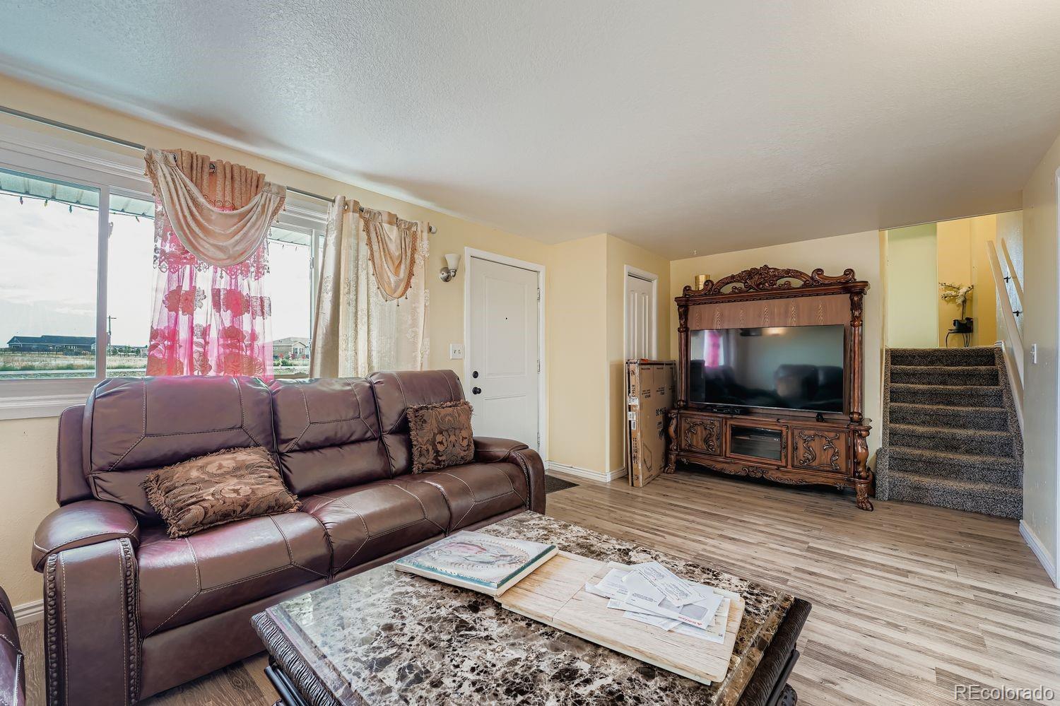 361 East Thomas Avenue Byers, CO 80103 - Photo 6 of 28 a living room with furniture and a flat screen tv