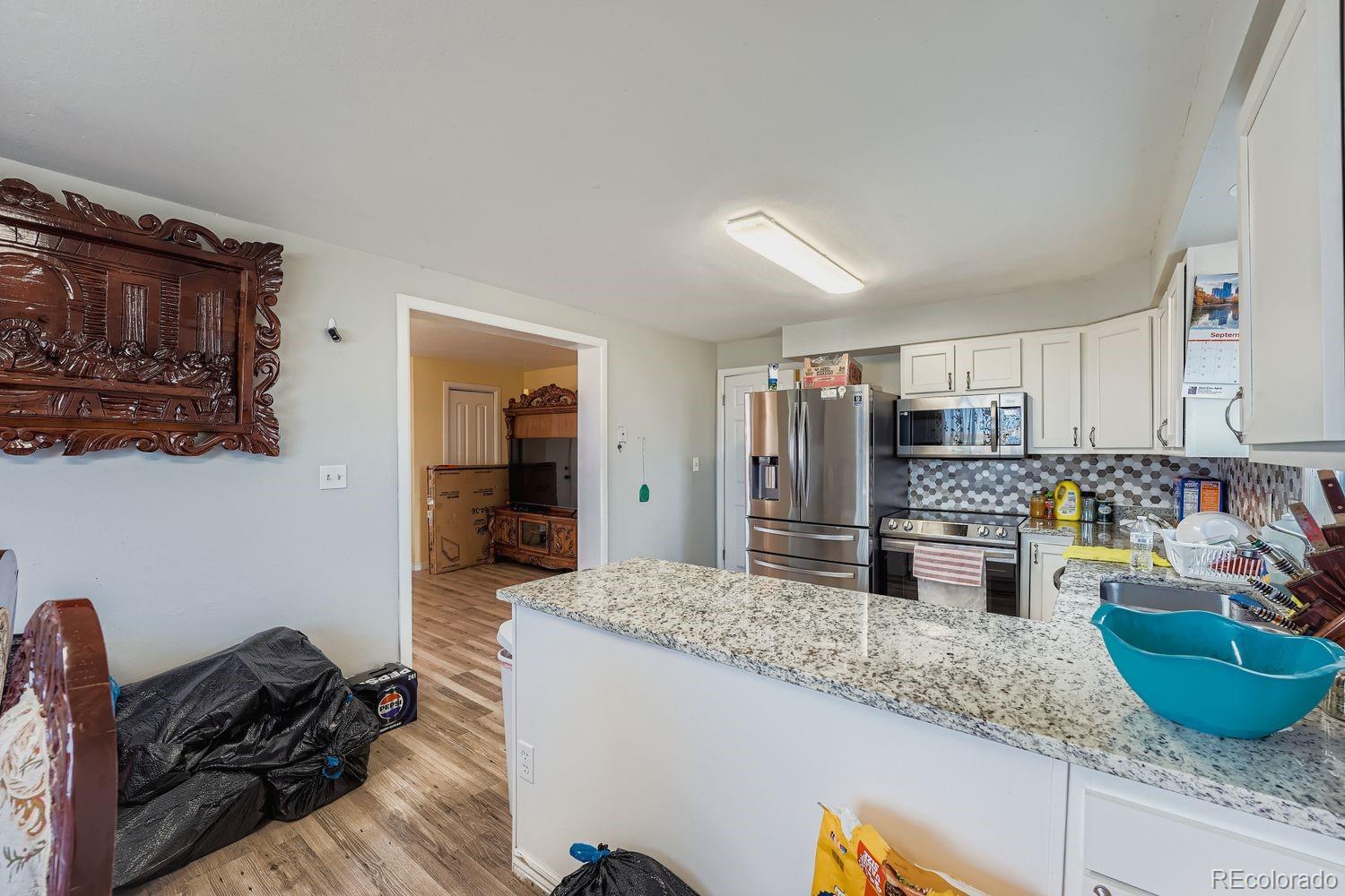 361 East Thomas Avenue Byers, CO 80103 - Photo 10 of 28 a kitchen with stainless steel appliances granite countertop a sink refrigerator and stove