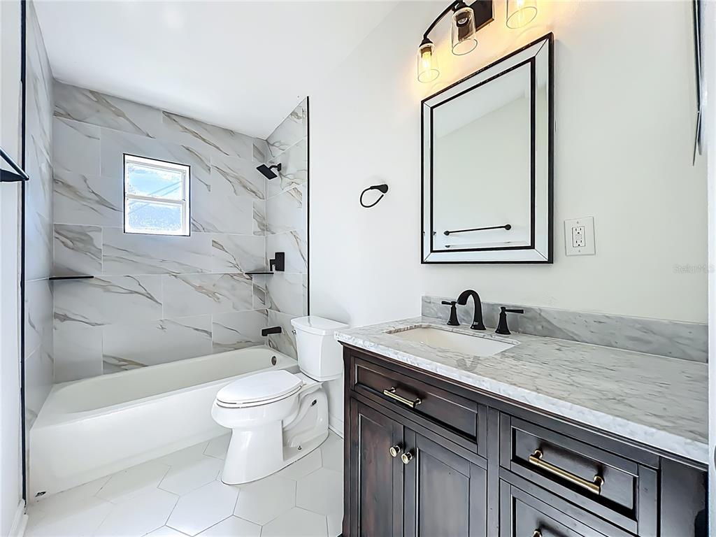 2001 Conway Gardens Road Orlando, FL 32812 - Photo 8 of 11 a bathroom with a granite countertop sink a toilet and a bathtub