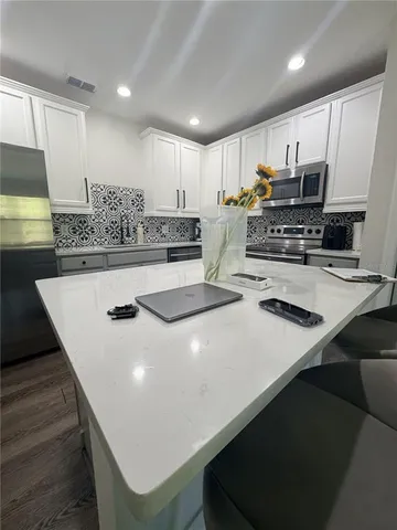 a kitchen with kitchen island a stove a sink and a refrigerator