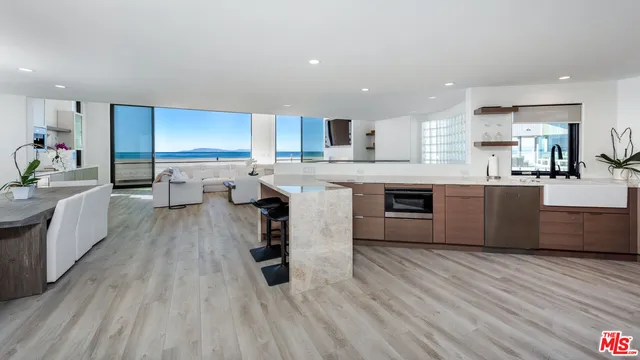 a large kitchen with stainless steel appliances a lot of counter space and a wooden floors