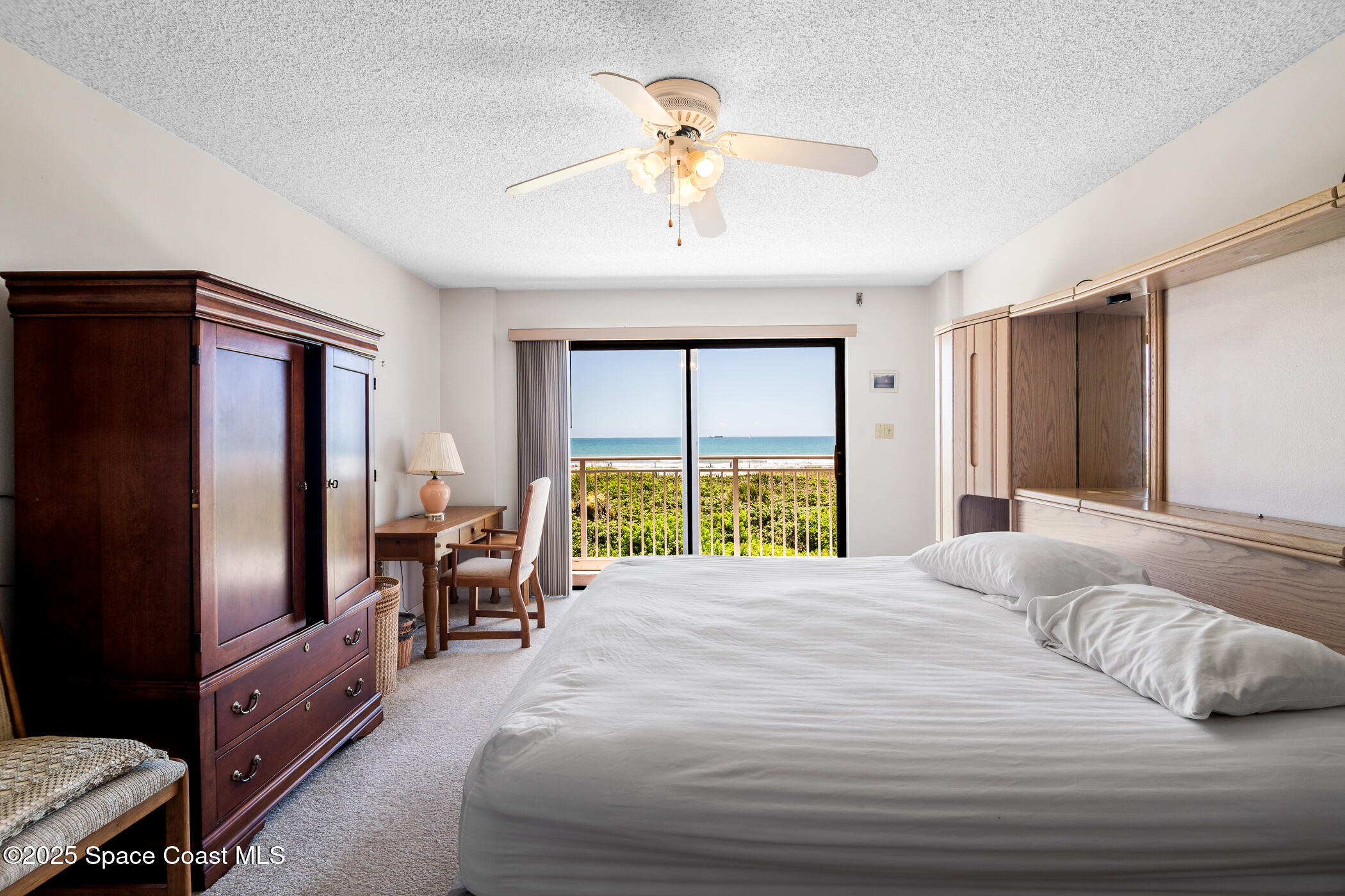 6770 Ridgewood Avenue, Unit 301 Cocoa Beach, FL 32931 - Photo 11 of 44 a large bedroom with a bed and a chandelier