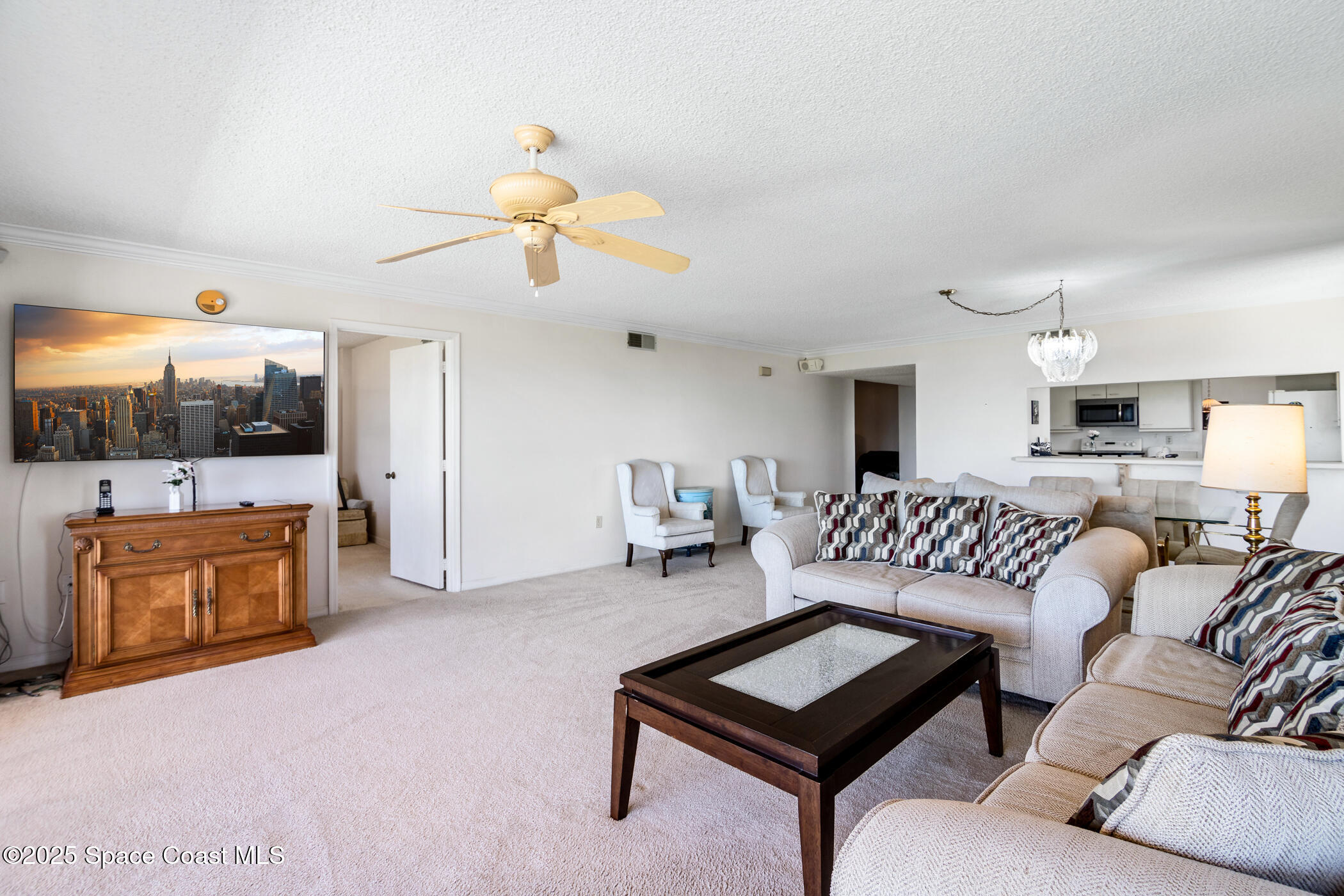 6770 Ridgewood Avenue, Unit 301 Cocoa Beach, FL 32931 - Photo 16 of 44 a living room with furniture and a flat screen tv