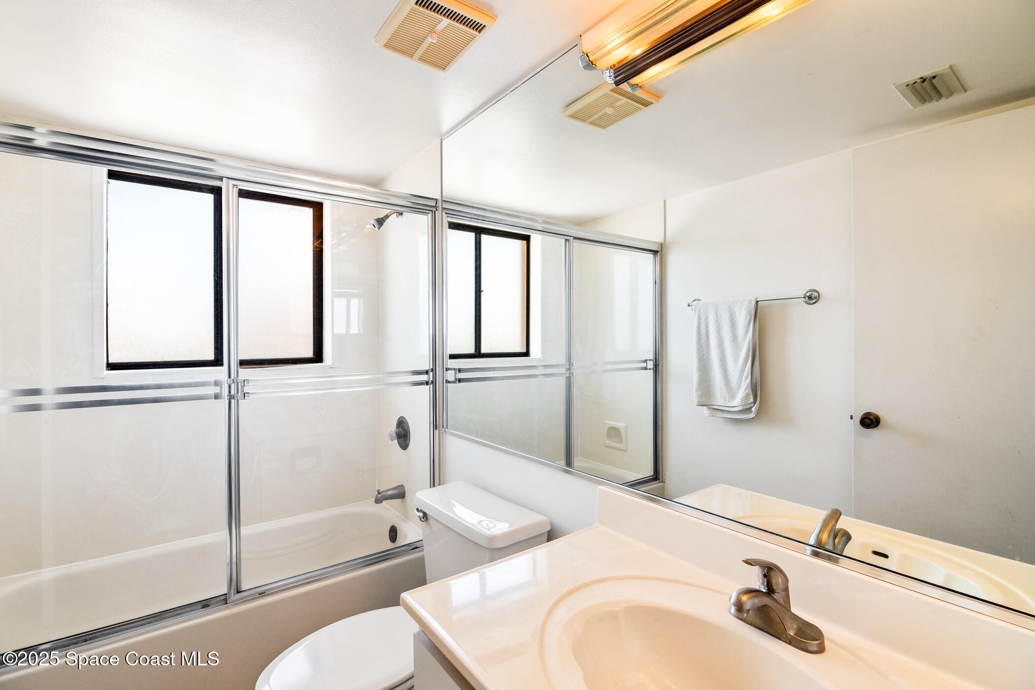 6770 Ridgewood Avenue, Unit 301 Cocoa Beach, FL 32931 - Photo 21 of 44 a bathroom with a sink toilet and shower