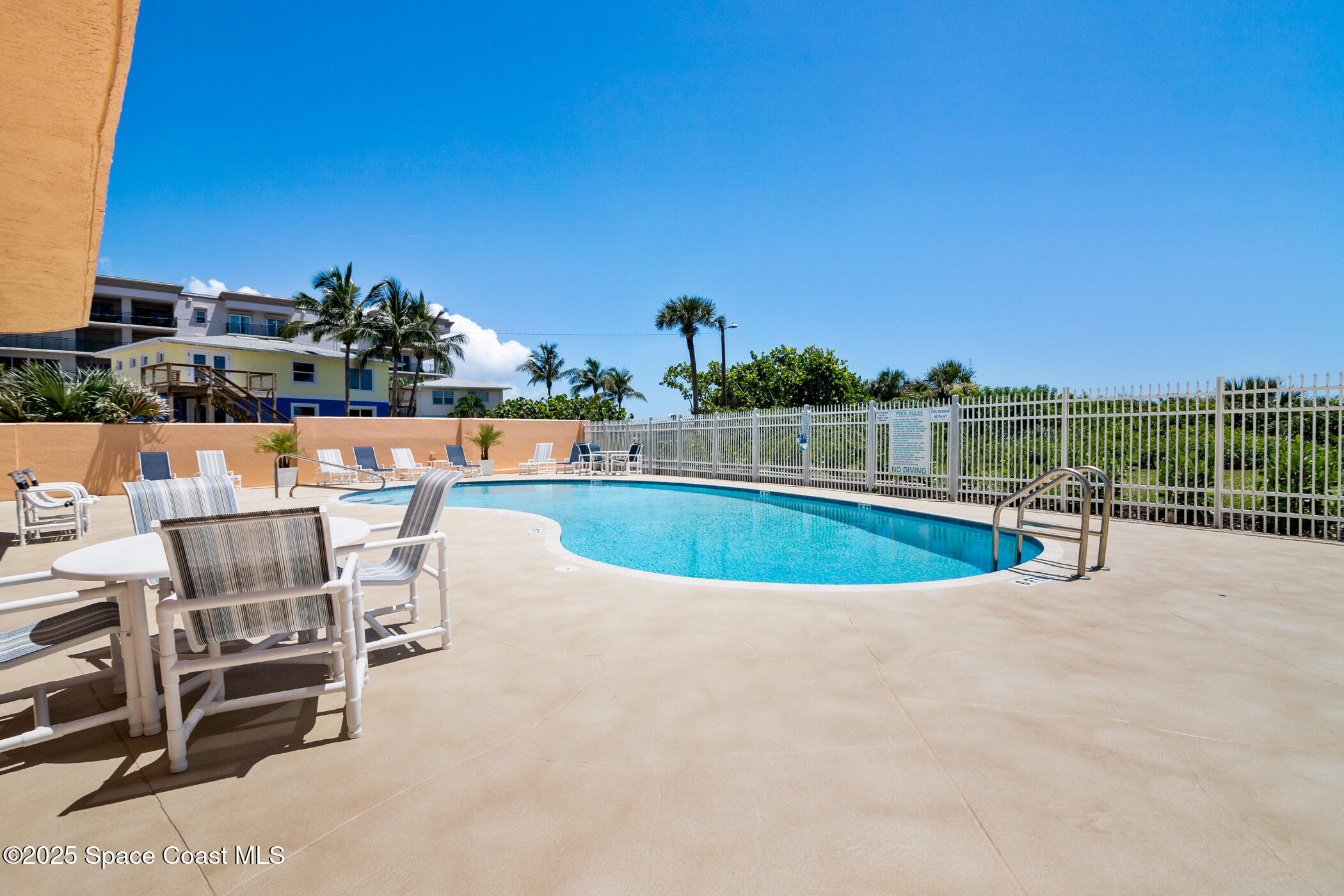 6770 Ridgewood Avenue, Unit 301 Cocoa Beach, FL 32931 - Photo 24 of 44 a view of a swimming pool with lawn chairs