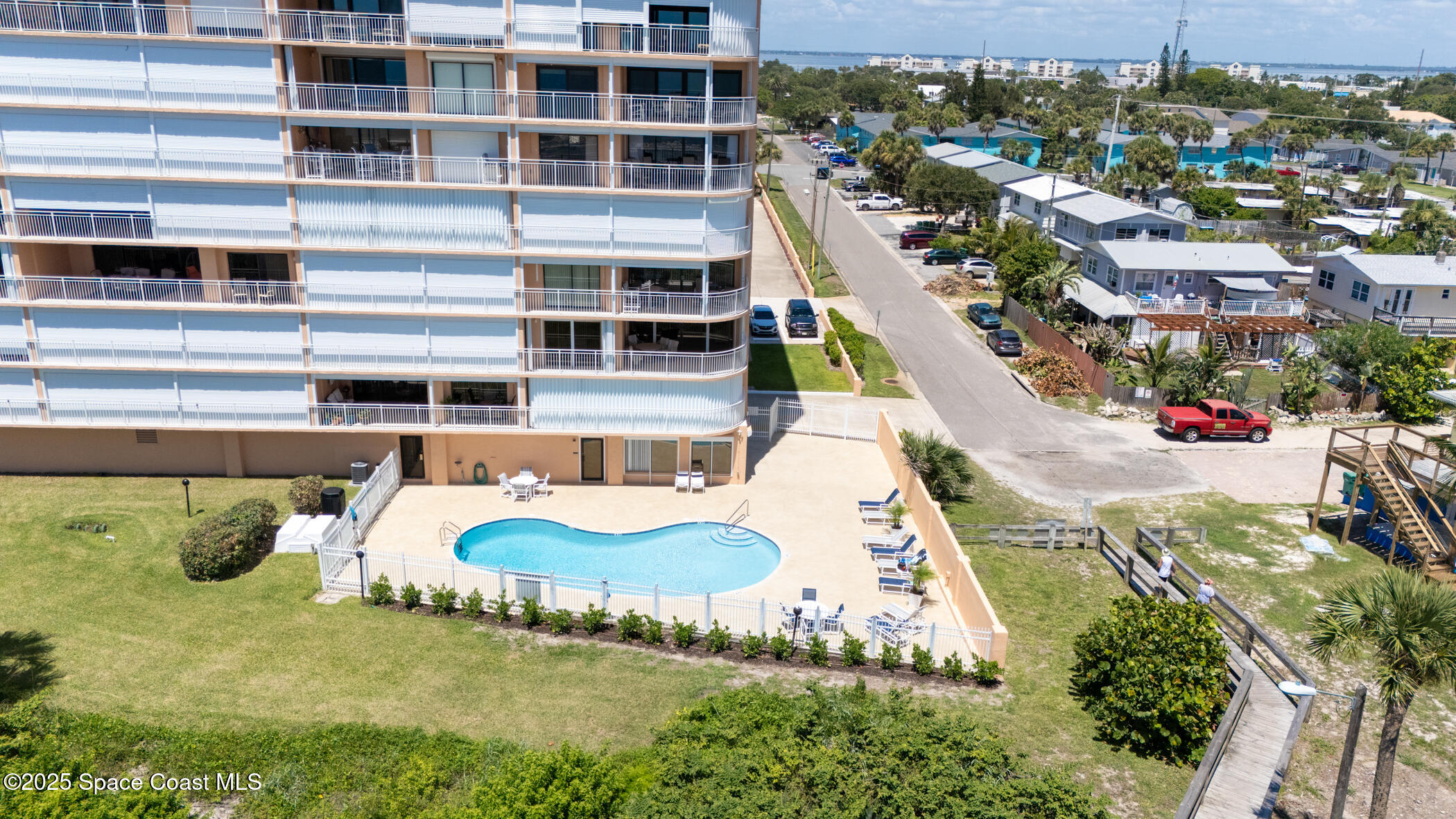 6770 Ridgewood Avenue, Unit 301 Cocoa Beach, FL 32931 - Photo 29 of 44 a view of a swimming pool with a lot of plants and trees