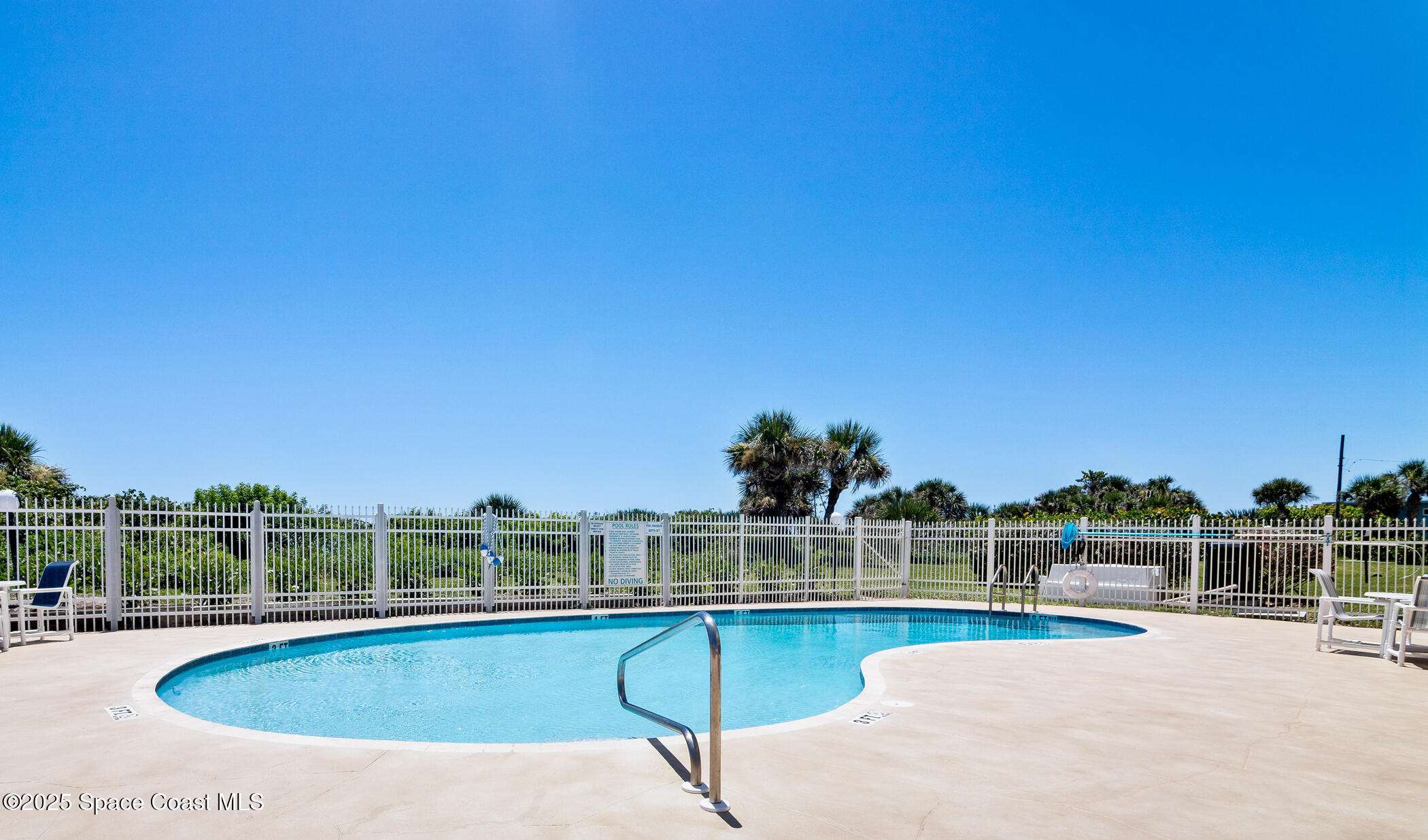 6770 Ridgewood Avenue, Unit 301 Cocoa Beach, FL 32931 - Photo 39 of 44 a view of a swimming pool with a lounge chair