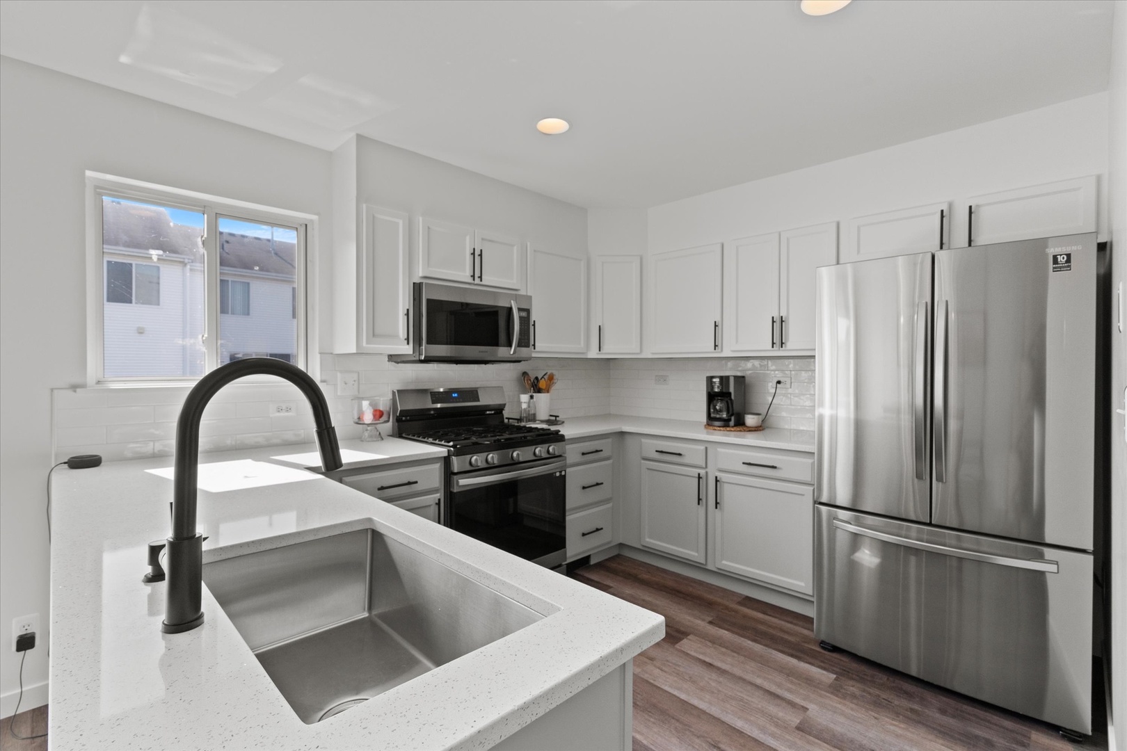 894 Clover Lane Pingree Grove, IL 60140 - Photo 5 of 24 a kitchen with a refrigerator sink and white cabinets