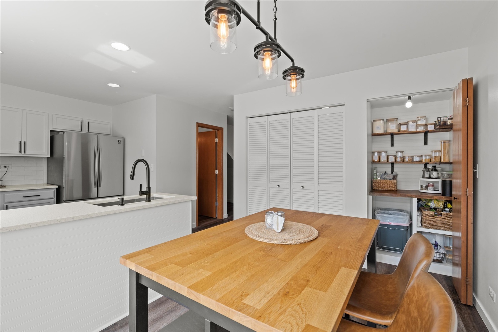 894 Clover Lane Pingree Grove, IL 60140 - Photo 8 of 24 a kitchen with stainless steel appliances granite countertop a sink a stove a refrigerator with a dining table and chairs