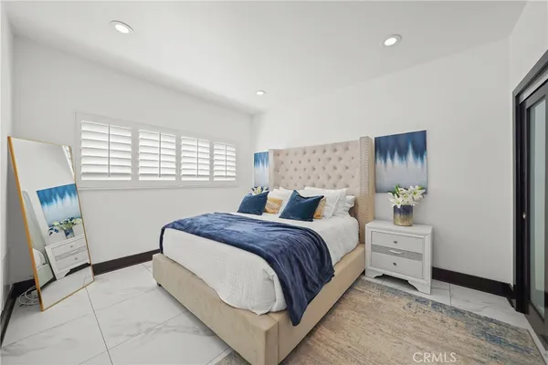 a bedroom with a large bed and a large mirror