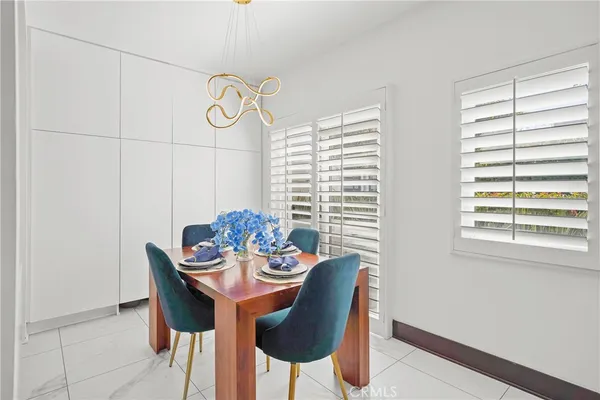 a dining room with furniture a large window and a chandelier