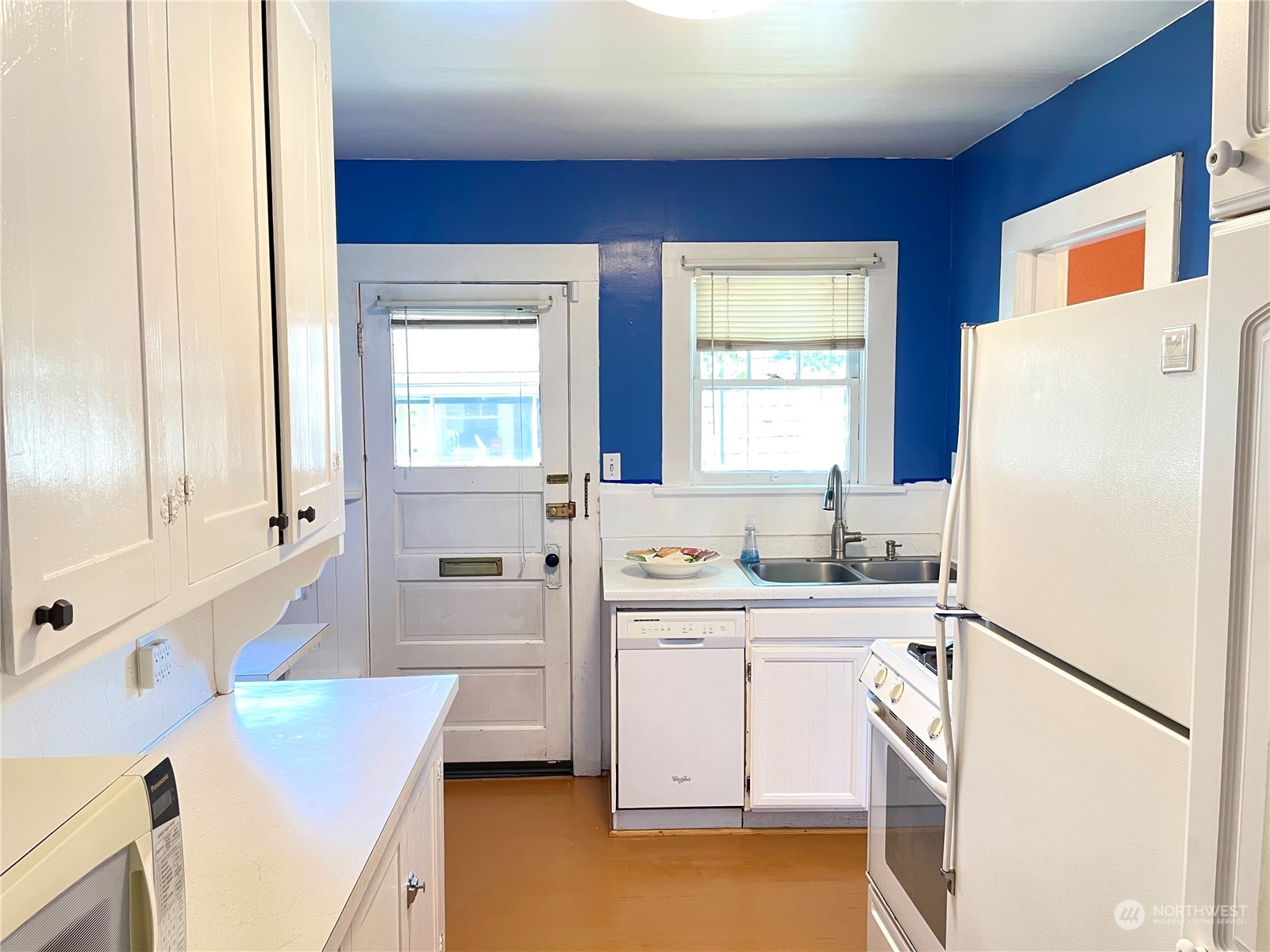 825 Northeast 63rd Street Seattle, WA 98115 - Photo 3 of 12 a kitchen with a sink a refrigerator a stove and a refrigerator