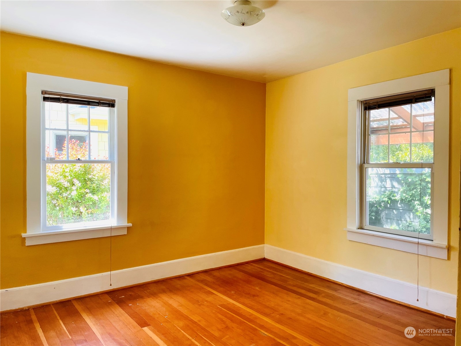 825 Northeast 63rd Street Seattle, WA 98115 - Photo 5 of 12 a view of an empty room with wooden floor and a window