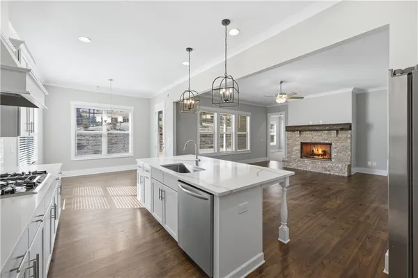 a kitchen with a stove a sink a center island and windows