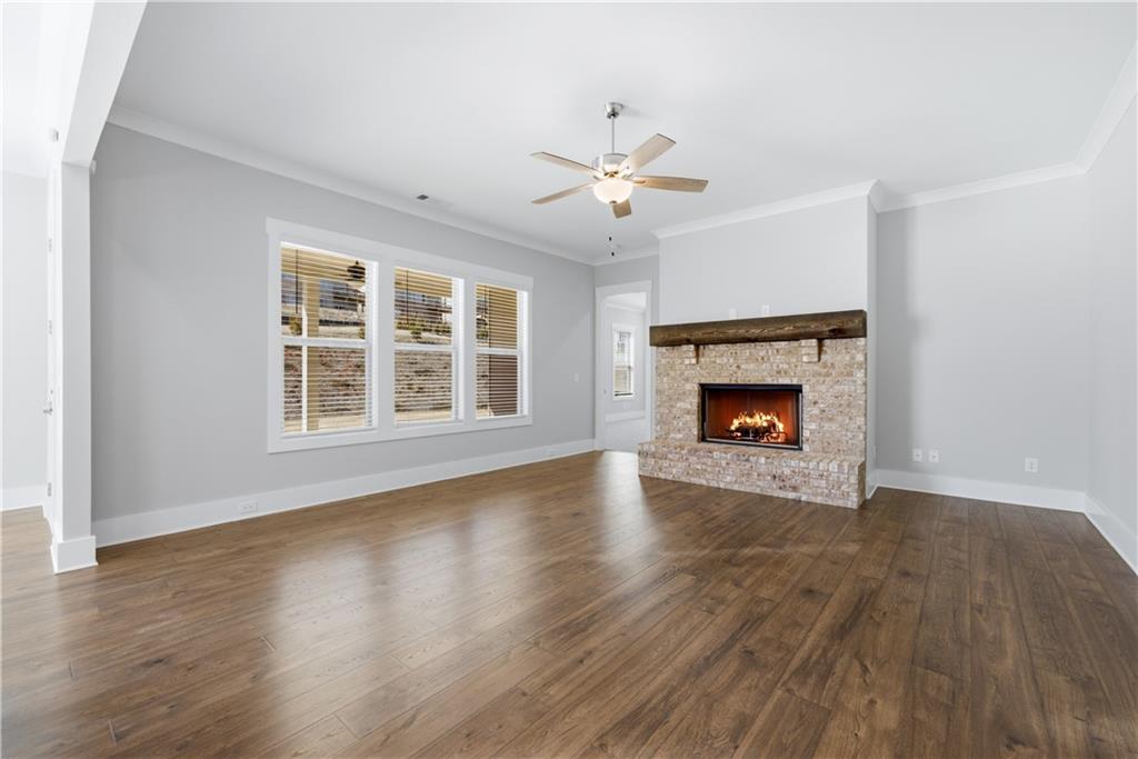 5706 Meadow View Drive Jefferson, GA 30549 - Photo 10 of 47 an empty room with wooden floor a ceiling fan and windows