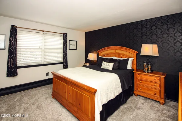 a bed sitting in a bedroom next to a window
