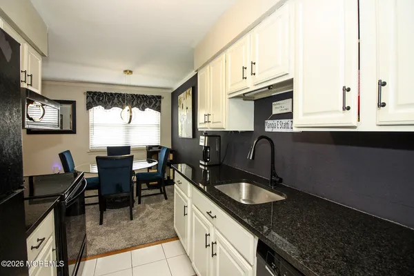 a kitchen with granite countertop sink stove and cabinets