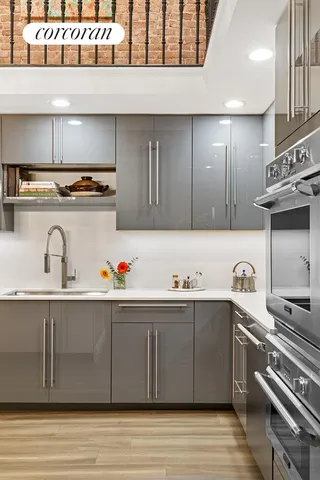 a kitchen with stainless steel appliances kitchen island granite countertop a table chairs sink and cabinets