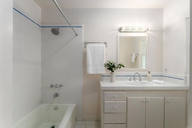 a bathroom with a granite countertop sink a mirror a vanity and a bathtub