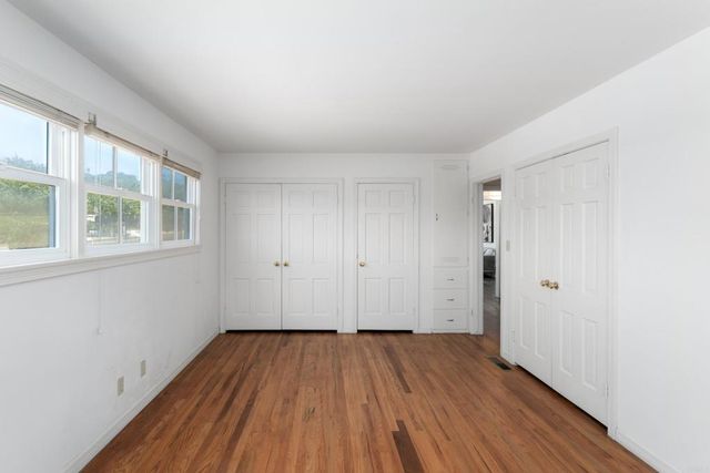 a view of a room with wooden floor and windows