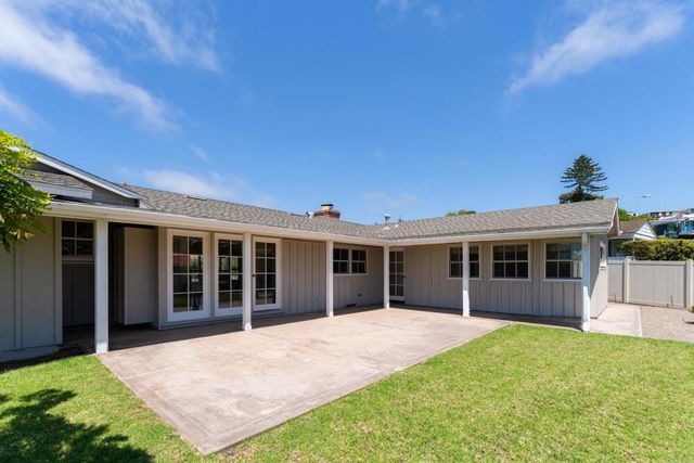 a view of a house with a yard and potted plants