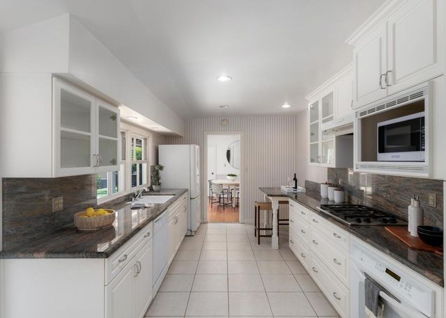 a large kitchen with stainless steel appliances granite countertop a sink and cabinets