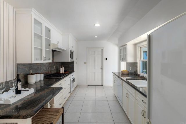 a kitchen with stainless steel appliances a sink stove and cabinets