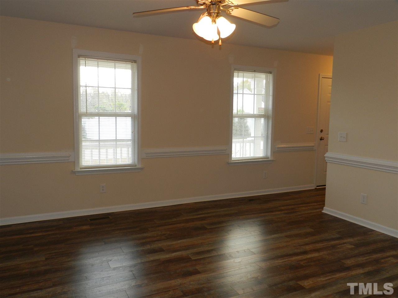 453 Axum Road Willow Spring, NC 27592 - Photo 6 of 17 an empty room with wooden floor and windows