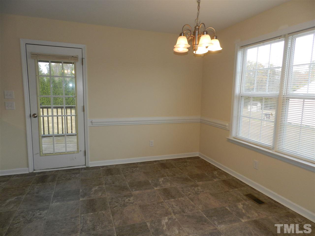 453 Axum Road Willow Spring, NC 27592 - Photo 9 of 17 en empty room with windows and chandelier