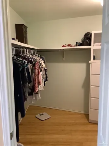 a view of walk in closet with clothes and shoes