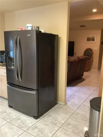 a view of a refrigerator in kitchen and a living room
