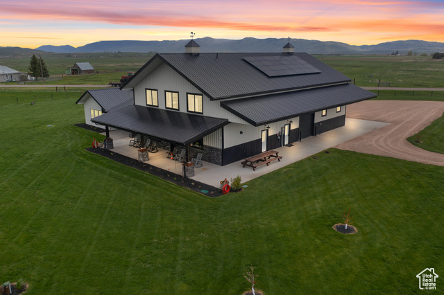 22 Old Ranch Road Montpelier, ID 83254 - Photo 1 of 1 Rear view of property with a patio, a mountain view, solar panels, and metal roof