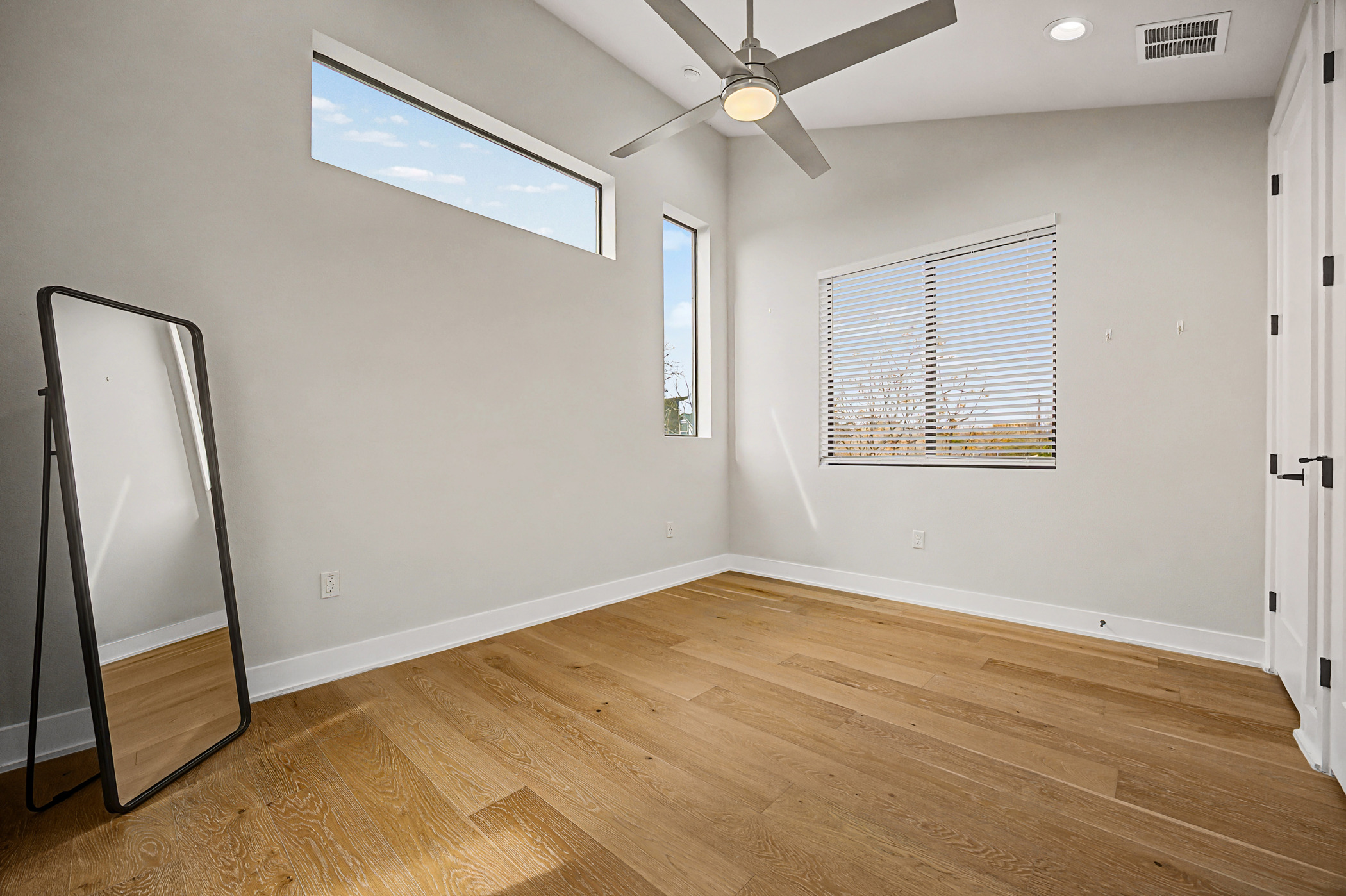 7102 Providence Avenue, Unit 2 Austin, TX 78752 - Photo 12 of 22 wooden floor in an empty room with a mirror