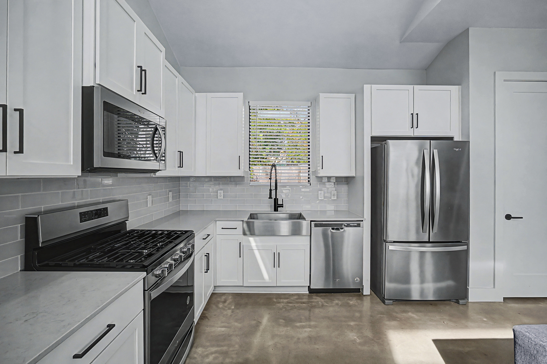 7102 Providence Avenue, Unit 2 Austin, TX 78752 - Photo 7 of 22 a kitchen with stainless steel appliances granite countertop a stove a refrigerator and a microwave