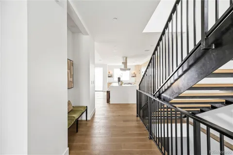a view of a hallway with wooden floor and staircase