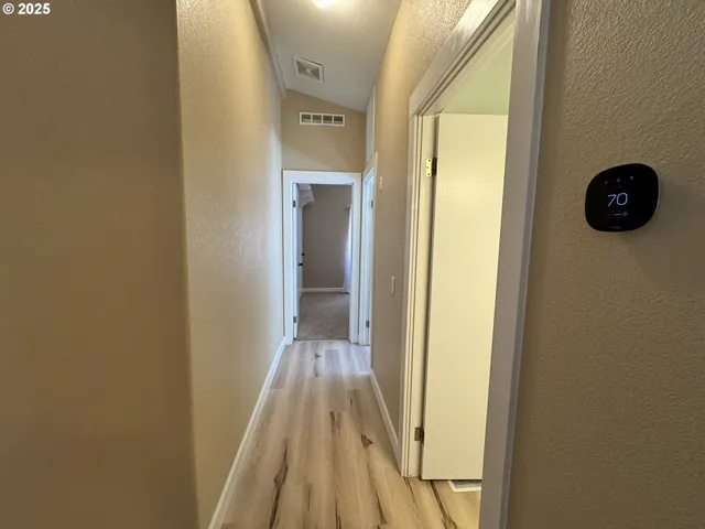 a view of a hallway with wooden floor and staircase