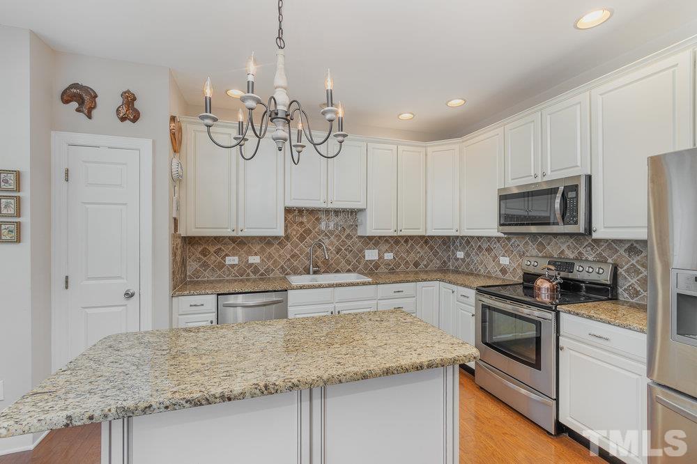 10122 Mizner Lane Raleigh, NC 27617 - Photo 11 of 31 a kitchen with stainless steel appliances granite countertop a sink stove and refrigerator