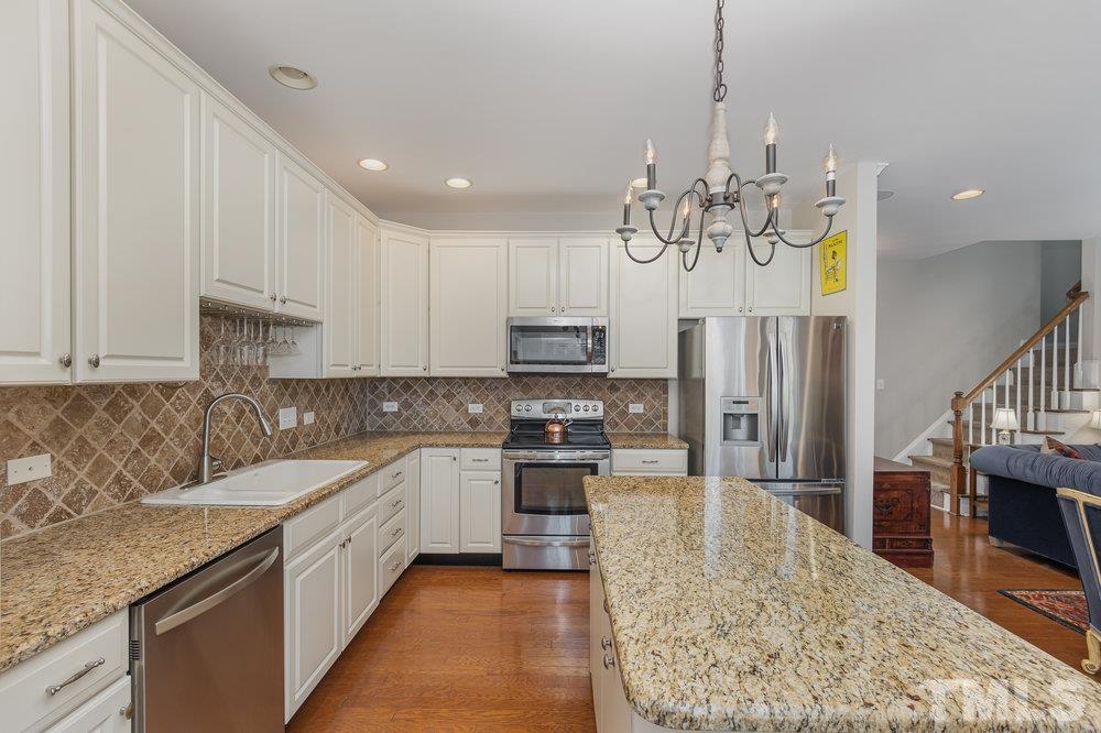 10122 Mizner Lane Raleigh, NC 27617 - Photo 12 of 31 a kitchen with stainless steel appliances granite countertop a sink stove and refrigerator