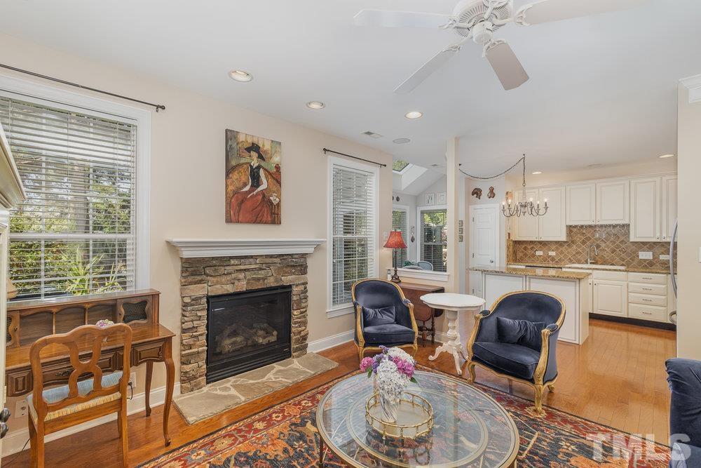 10122 Mizner Lane Raleigh, NC 27617 - Photo 14 of 31 a living room with furniture a fireplace and a floor to ceiling window