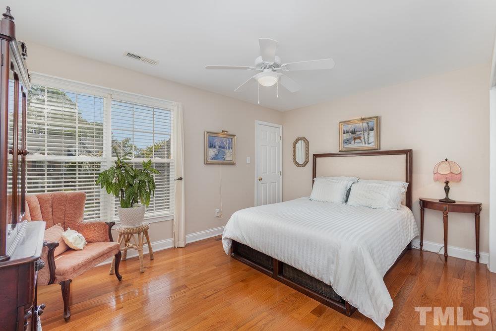 10122 Mizner Lane Raleigh, NC 27617 - Photo 20 of 31 a bedroom with a bed and chair