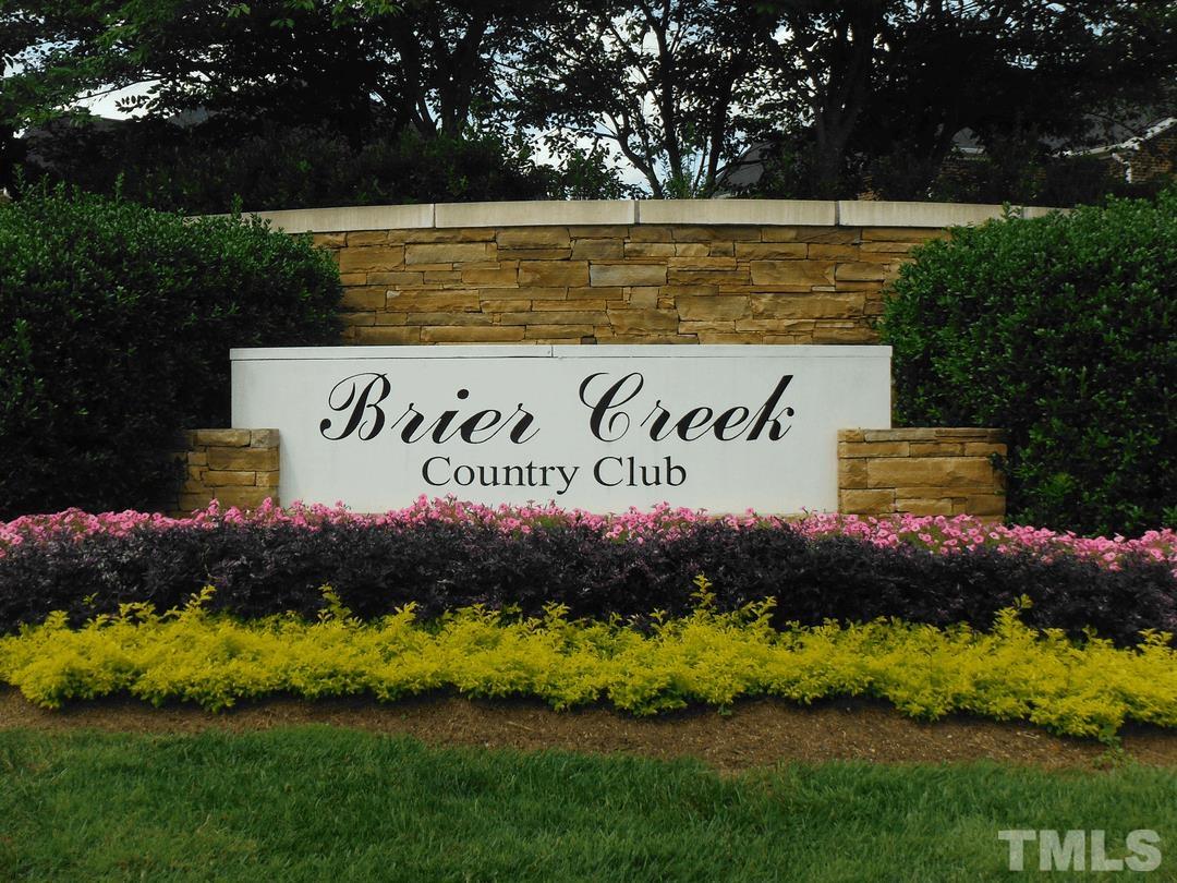 10122 Mizner Lane Raleigh, NC 27617 - Photo 27 of 31 a sign that is sitting on a lush green field near a lake