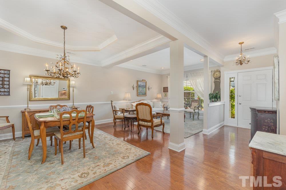 10122 Mizner Lane Raleigh, NC 27617 - Photo 7 of 31 a view of a dining room and livingroom with furniture wooden floor a chandelier