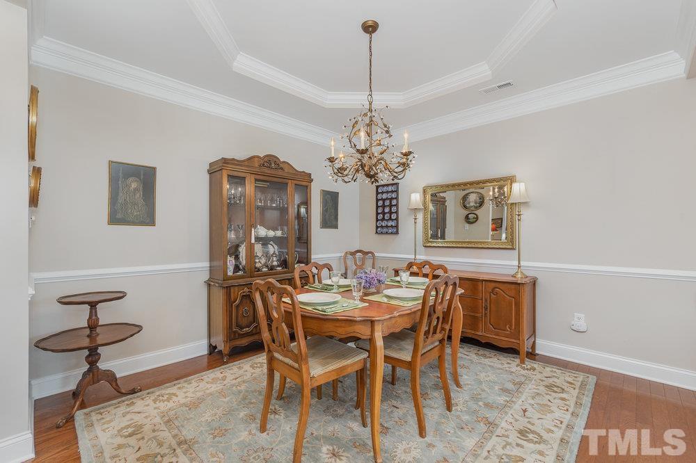 10122 Mizner Lane Raleigh, NC 27617 - Photo 9 of 31 a dining room with furniture a chandelier and wooden floor
