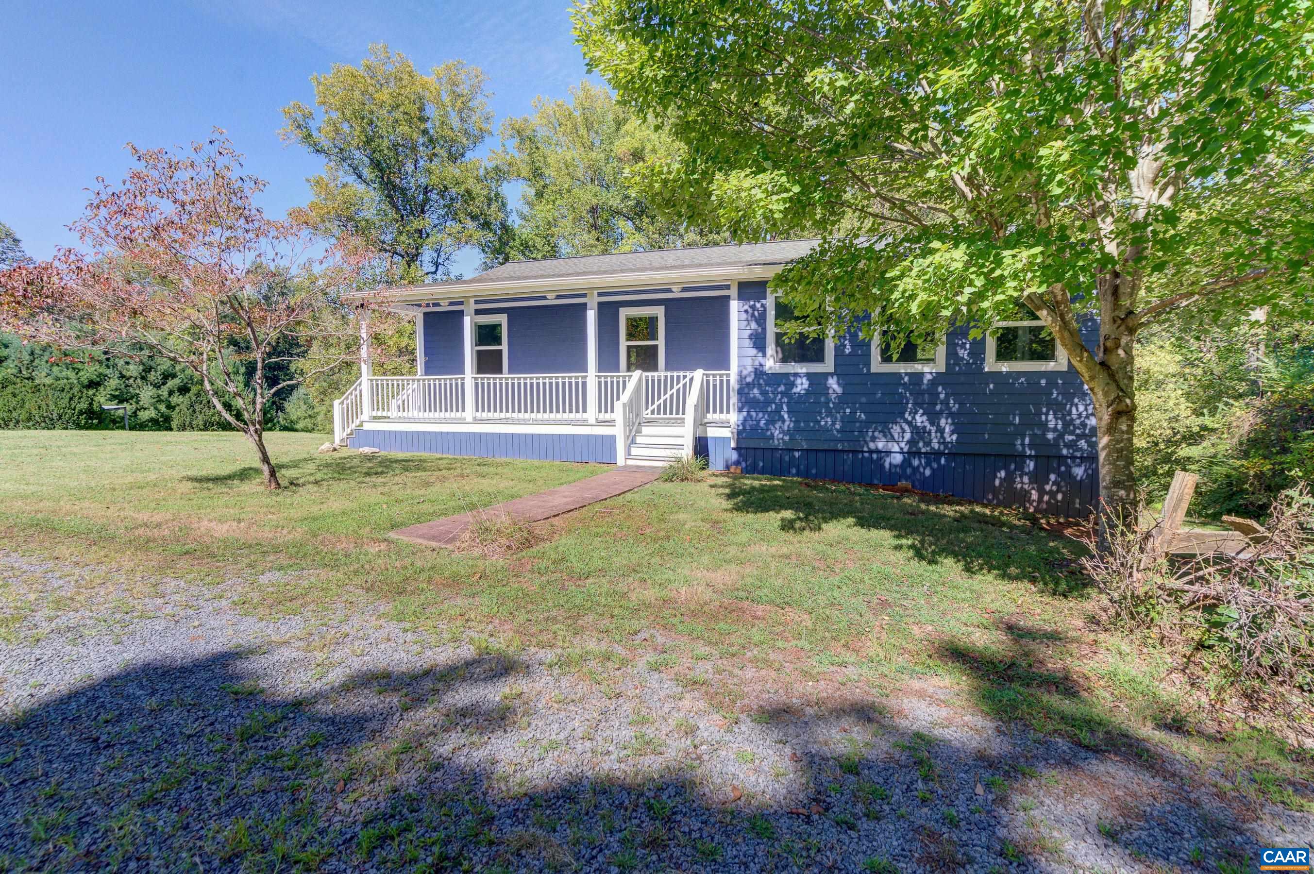 a view of a yard in front of a house with large tree