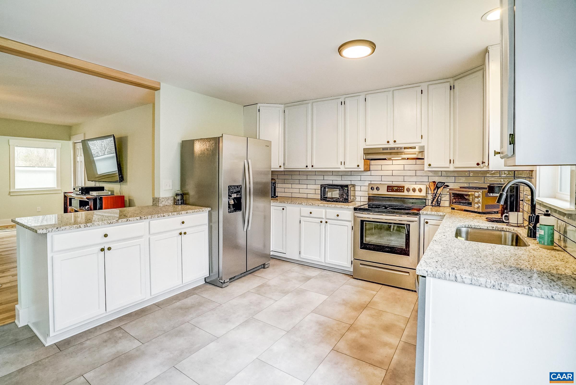 1265 Pounding Creek Road Charlottesville, VA 22903 - Photo 23 of 71 a kitchen with granite countertop a sink stainless steel appliances and white cabinets