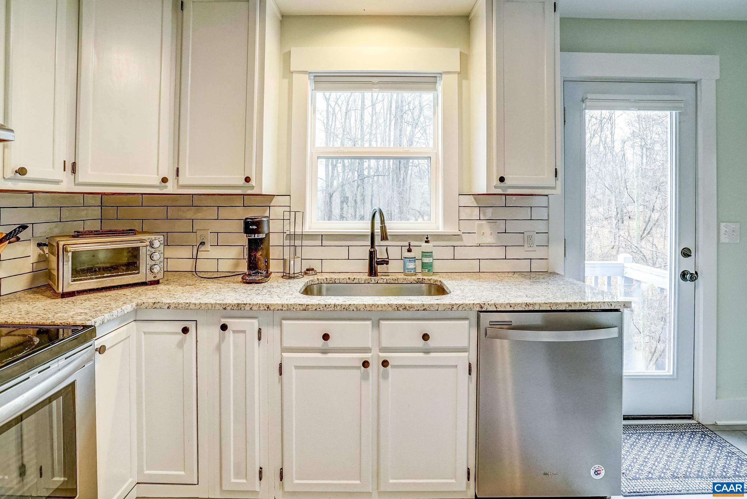 1265 Pounding Creek Road Charlottesville, VA 22903 - Photo 24 of 71 a kitchen with granite countertop white cabinets and a window