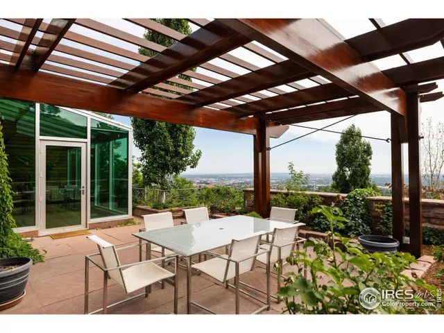 a view of a patio with a table and chairs under a large umbrella